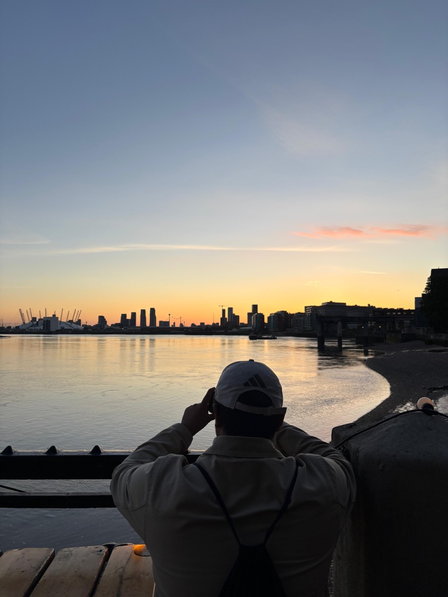 Hafiz photographing the sunset over the Thames with the O2 arena on the skyline